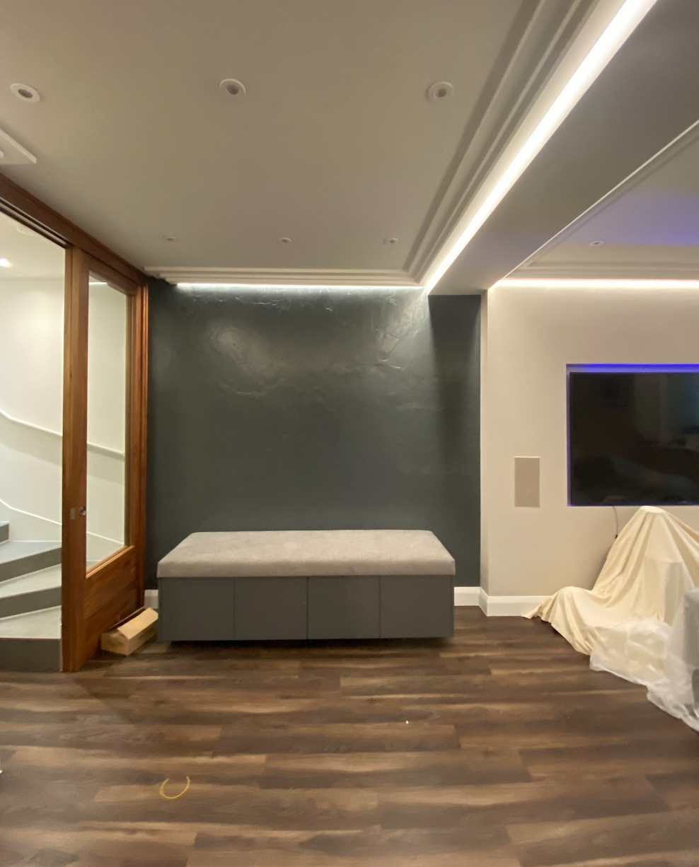 Recessed LED cove lighting along the ceiling edge of a finished room