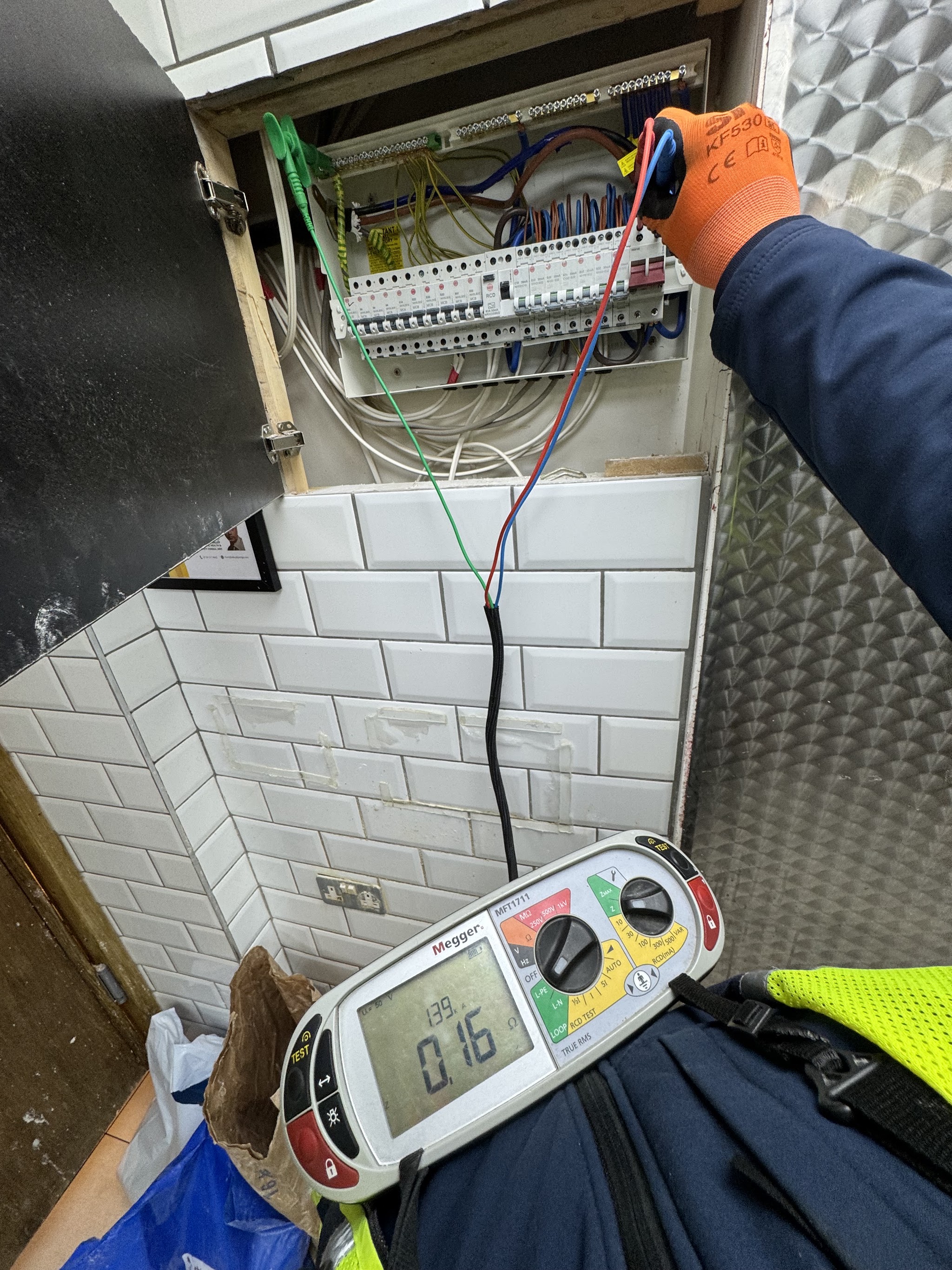Multifunction tester connected to a consumer unit during an inspection